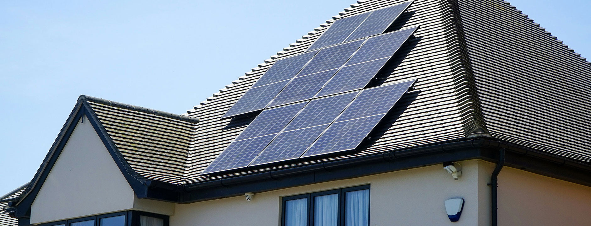 Solar panels on a house roof with clear blue sky