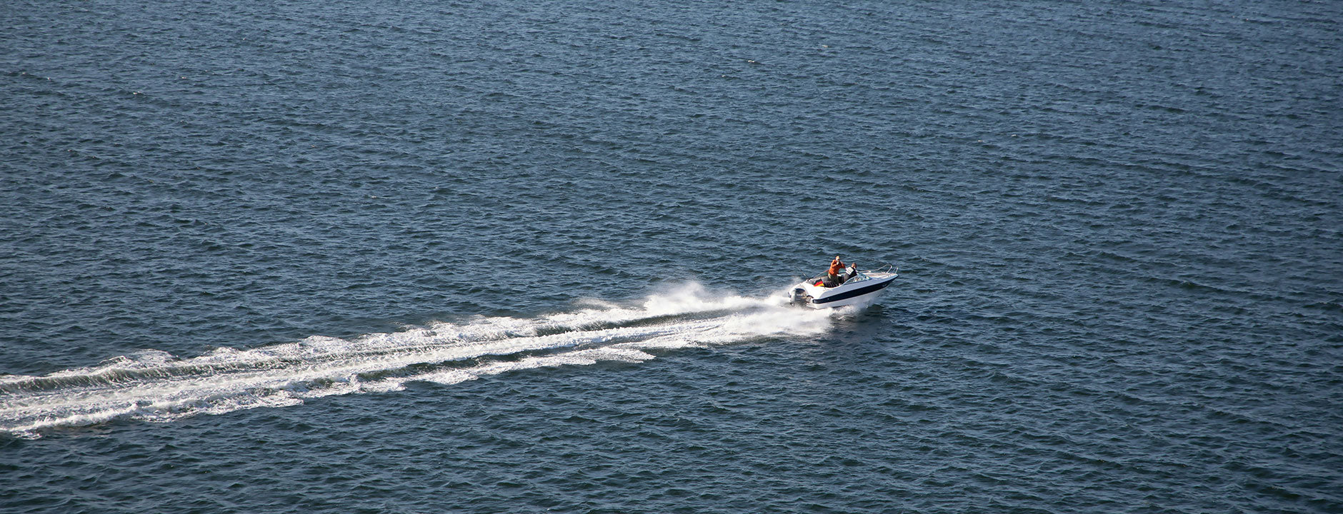 Speedboat on a body of water with a clear sky